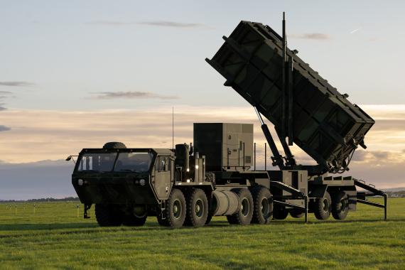 Large military vehicle equipped with a missile launching system on a grassy field